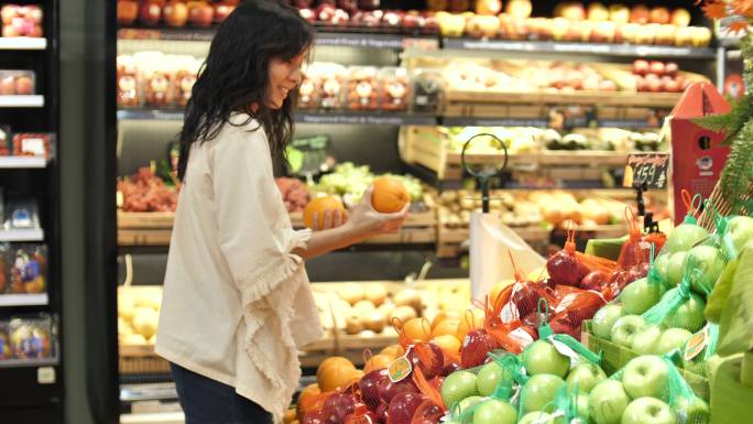 在超市挑选水果的女人