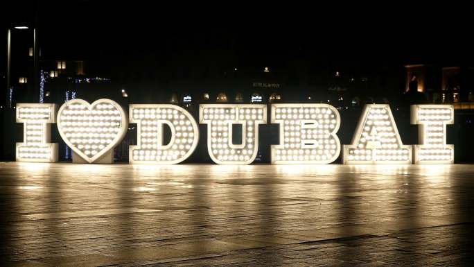 夜晚，人们在点亮的“我爱迪拜”标志前经过