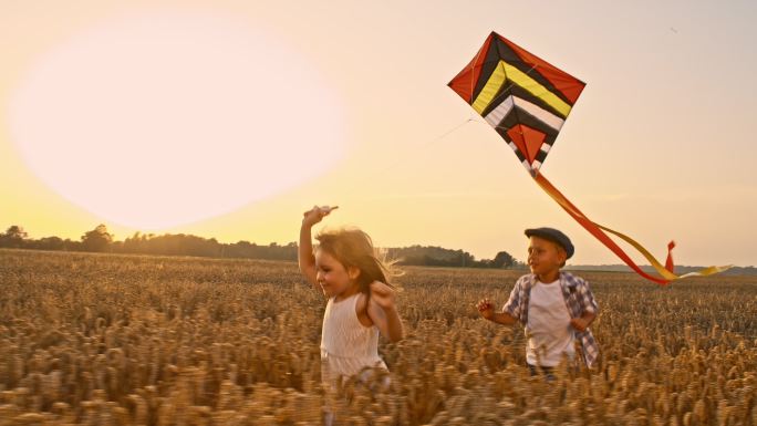女孩和男孩在稻田中奔跑一起放风筝