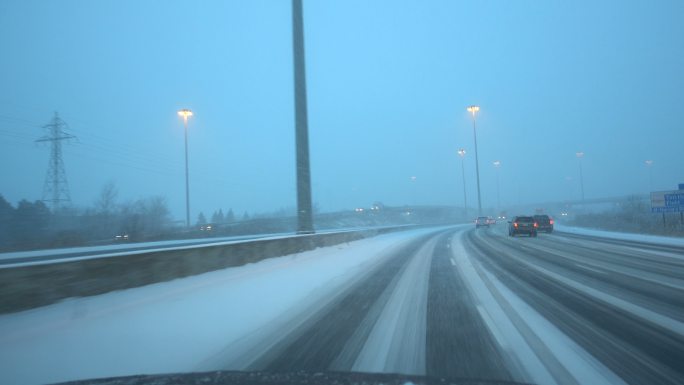 开车在积雪覆盖的高速公路上行驶