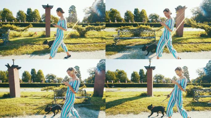 一个美丽的女人在公园里和她的狗散步。