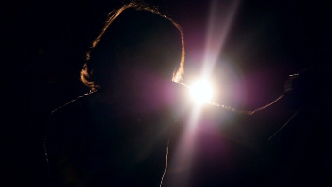 一个女孩在黑暗中拳击的剪影。