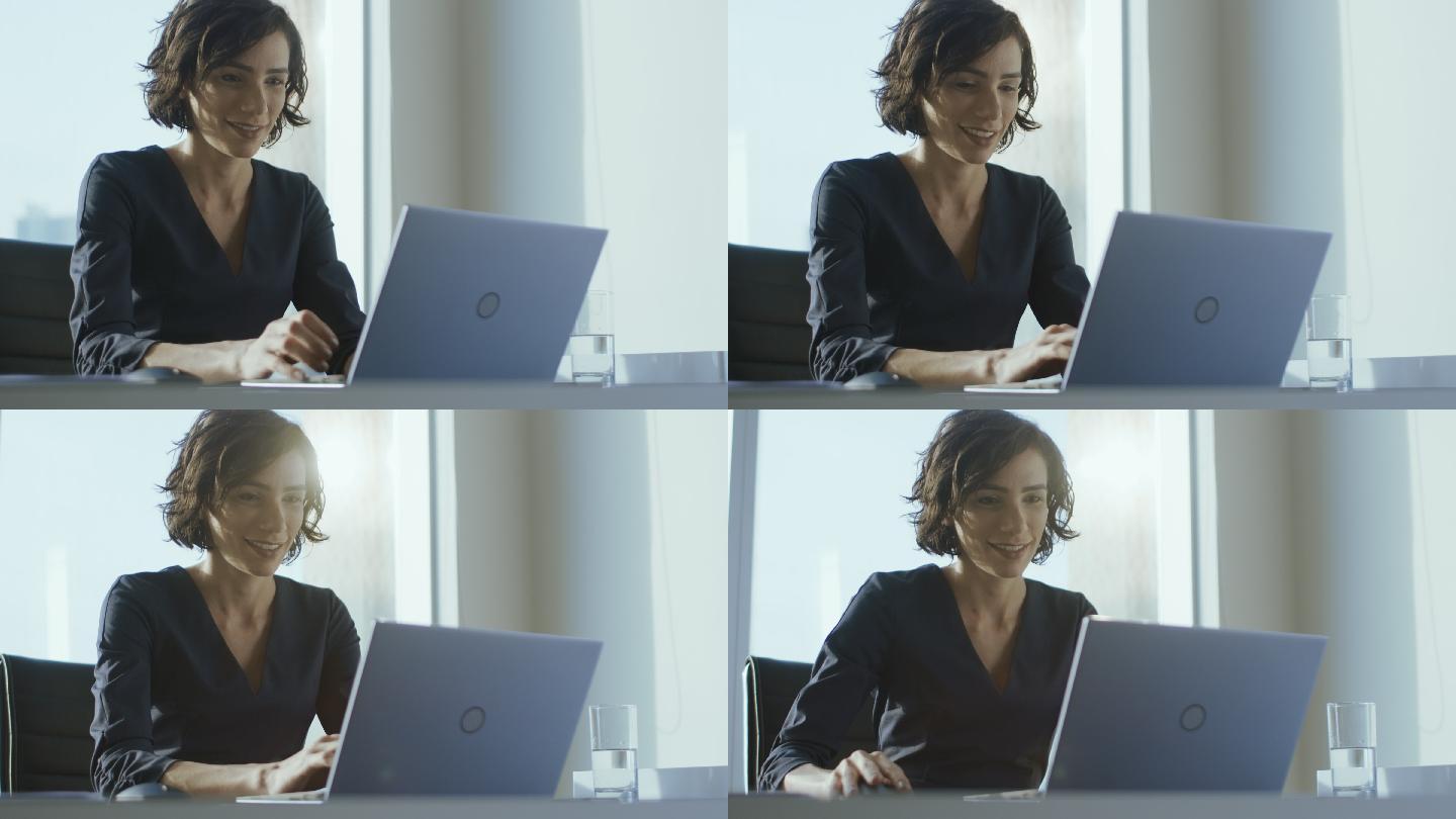 女高管坐在办公桌旁的笔记本电脑上工作