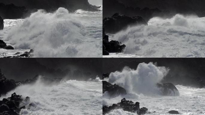 巨浪滚向岩石海岸。海浪拍打的浪花飞过