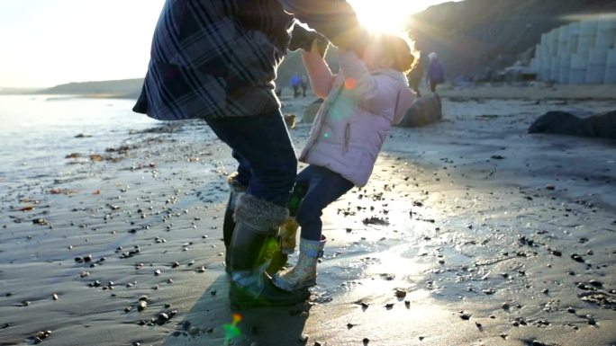 父亲和女儿在沙滩上玩耍