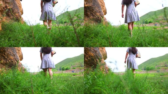 女子走在大山草原之间