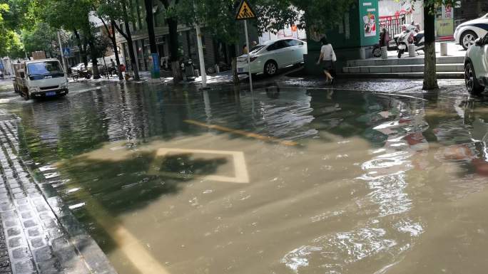 汽车驶过雨水积水的城市街道马路道路