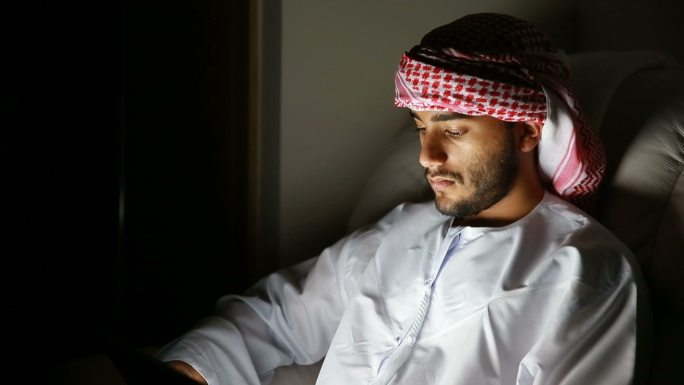 年轻的阿拉伯人在房间里使用数字平板电脑