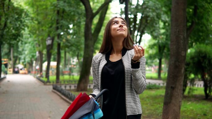 一位年轻的黑发女子在公园打开伞。