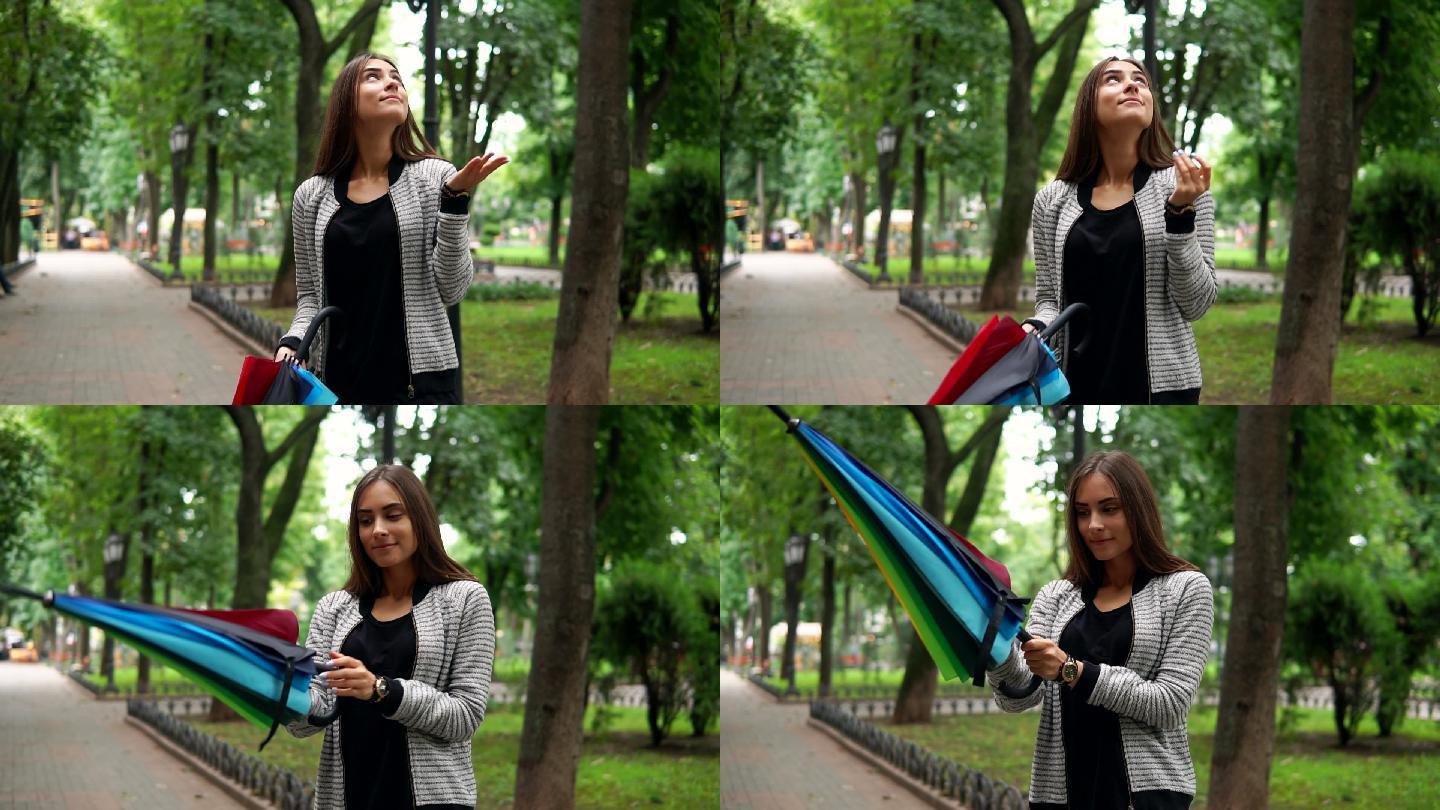 一位年轻的黑发女子在公园打开伞。