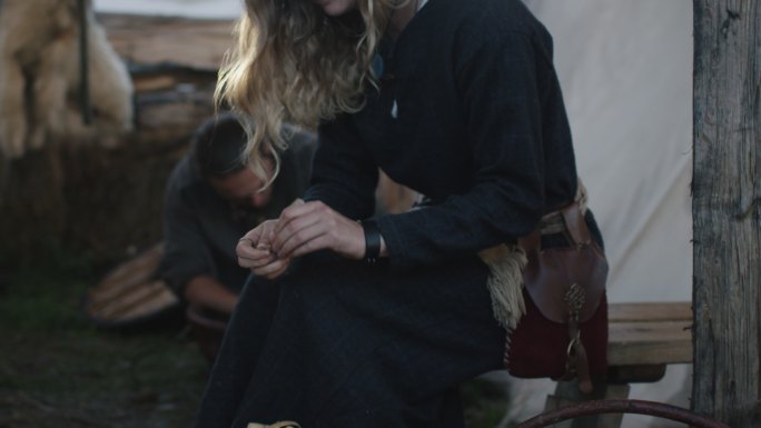 穿着中世纪服装的妇女用木头干活。
