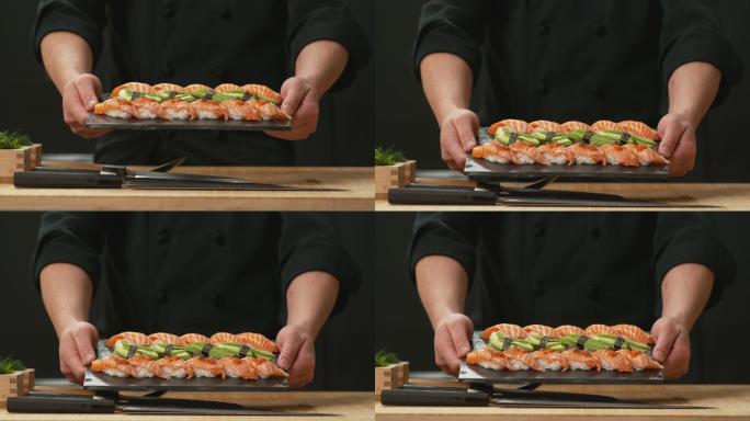 厨师端出一盘新鲜寿司