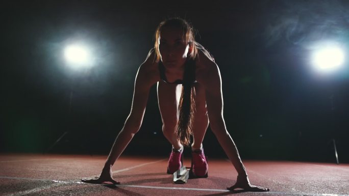 职业女子运动员在体育场跑道上进行短跑。