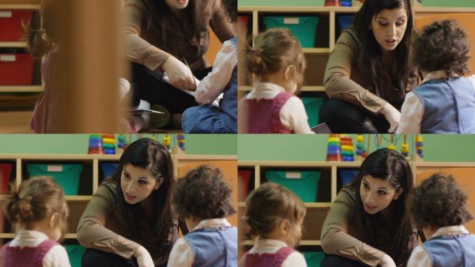 幼儿园老师带着两个女婴看书