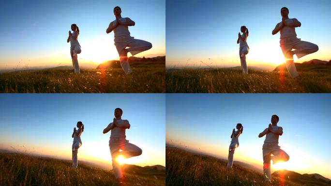 日落时分，一对情侣在草地上练习瑜伽