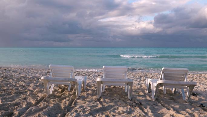 三张沙滩椅放在海边