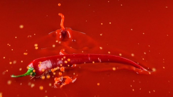 红辣椒碰到了红酱汁的表面。