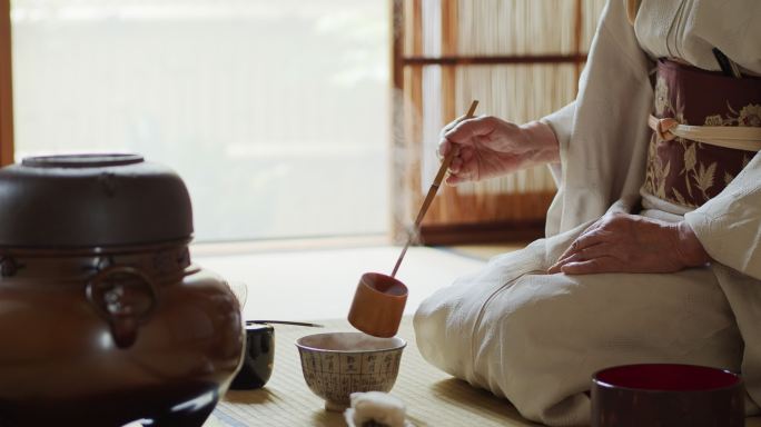 日本仪式主持人量茶碗里的水