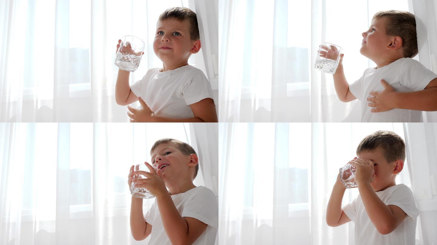 一个小男孩手里拿着一杯水在喝
