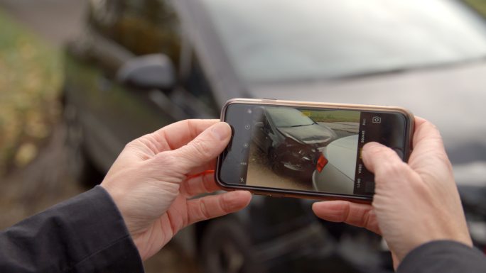 男子用手机拍车祸照片