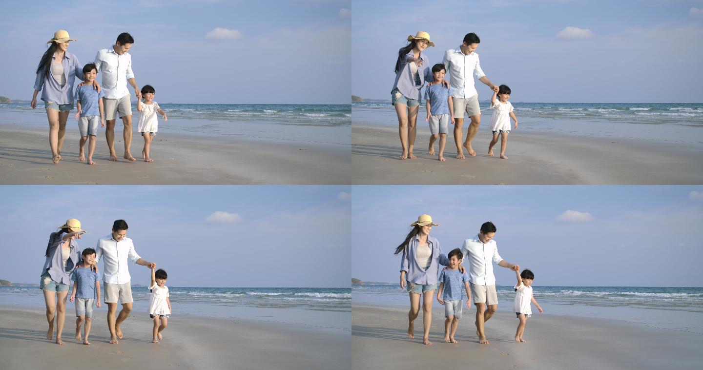 快乐的一家在沙滩上散步。家庭、度假和旅游概念。