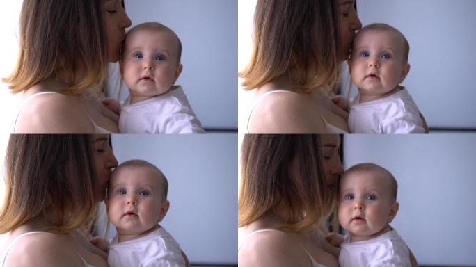 深情的母亲抱着漂亮的小女孩亲吻