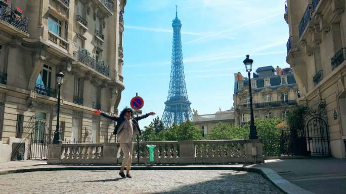 女人走巴黎街头，背景是巴黎的埃菲尔铁塔