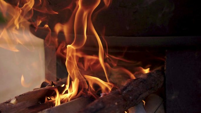 燃烧的柴火火焰，土灶上的炊烟袅袅