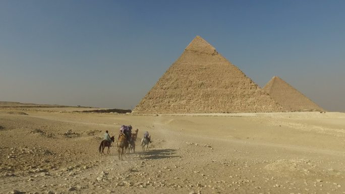 游客骑着骆驼在吉萨大金字塔