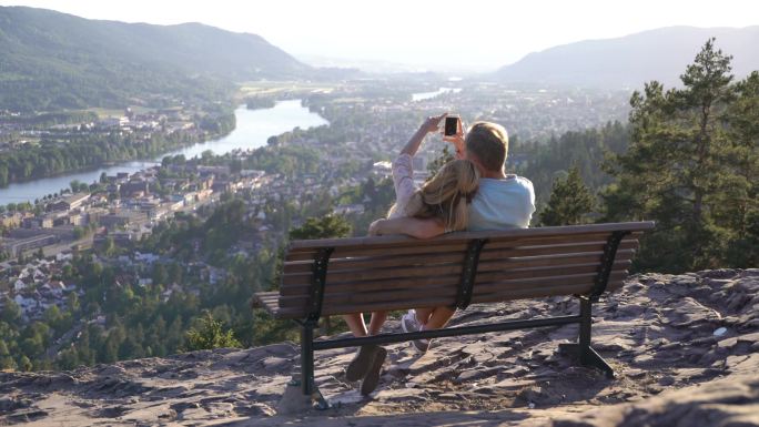 浪漫情侣坐在木凳上欣赏风景