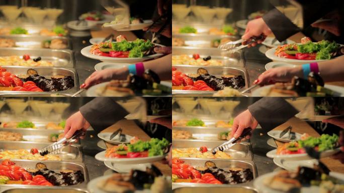 人们在自助餐加食物。