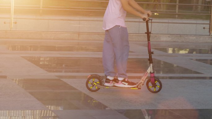 升格慢动作城市阳光下玩滑轮车的孩子