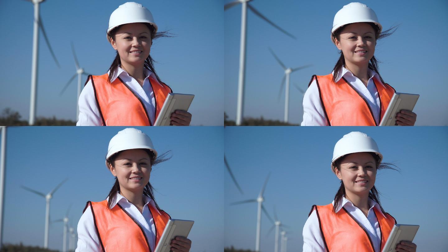微笑的女工程师站立在风力涡轮机前