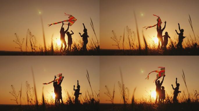 快乐的家庭在日落时玩风筝。