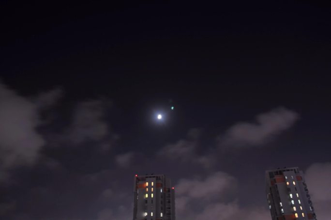 城市延时拍摄夜间云和月亮