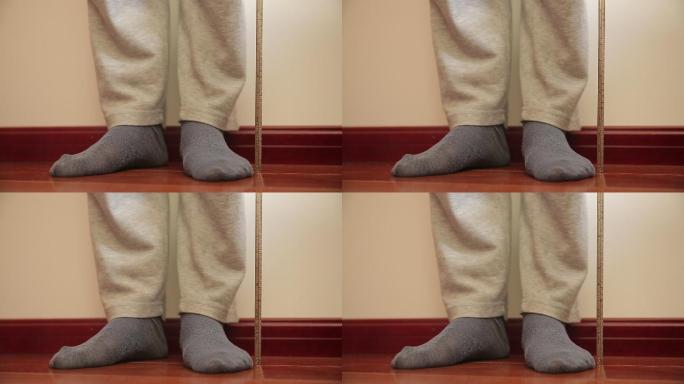 老人靠墙用尺子量身高 (1)