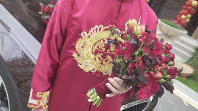 中式服装的新郎拿着手捧花