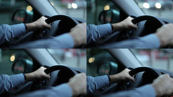 驾驶汽车的方向盘上人的手的特写。
