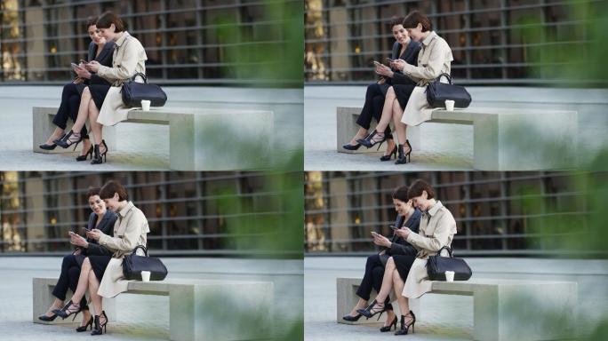 城市里坐在长椅上使用手机的女人