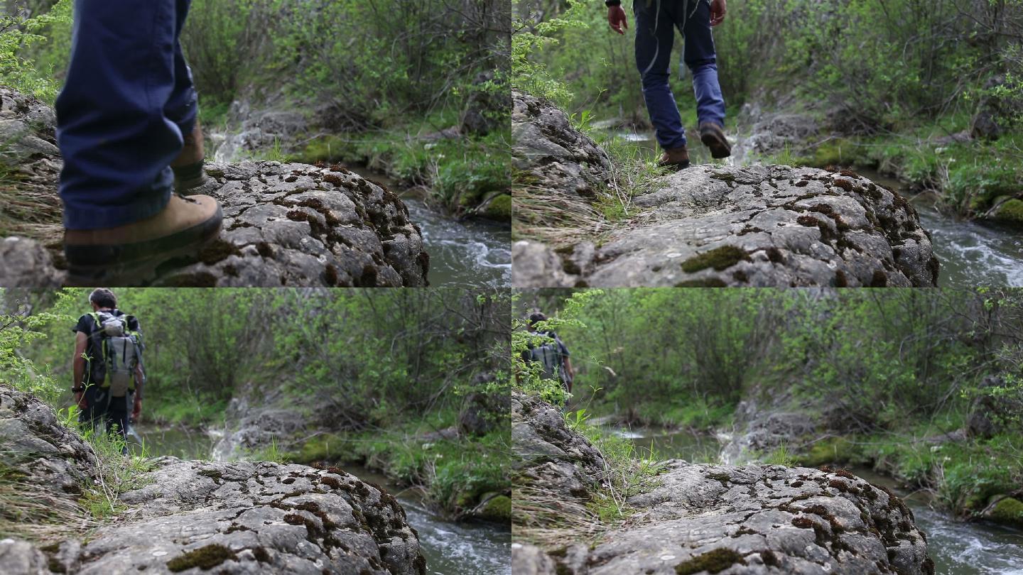 探险家走在河边的一条岩石小道上