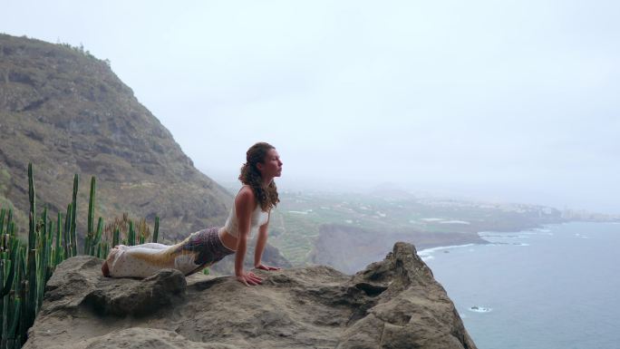 在岩石上练瑜伽的女子