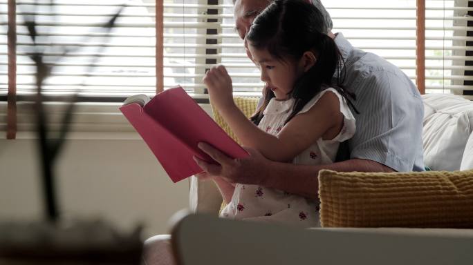 小女孩和爷爷在家看故事书