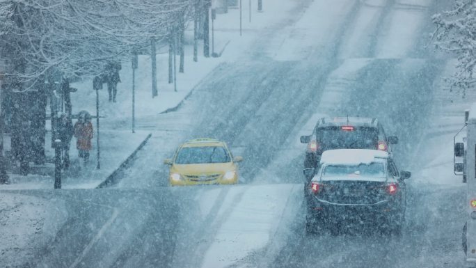 暴风雪中穿过繁忙道路的人们