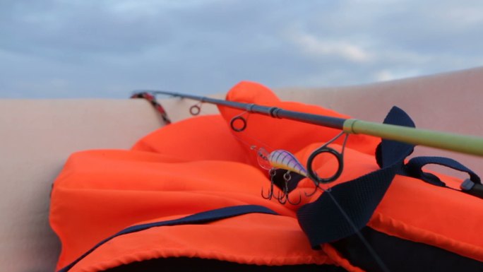 橙色救生衣和鱼竿