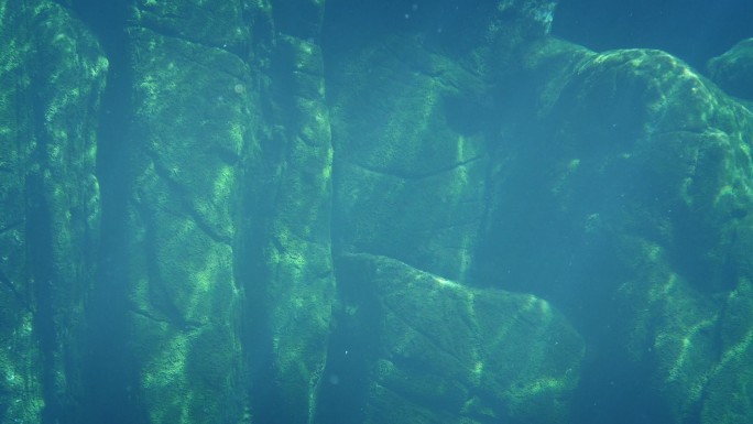 阳光涟漪中的水下古老岩石结构