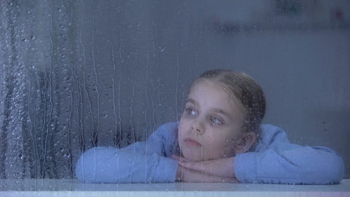 雨天孤独的女孩在窗台上看着远方