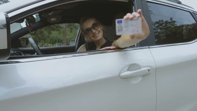 年轻快乐的女人展示她的新驾照