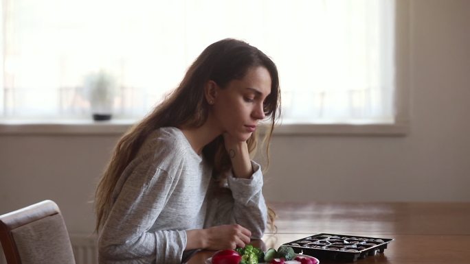 在沙拉和糖果之间做出选择的年轻女子