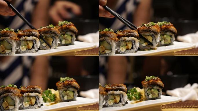 用筷子夹起寿司卷