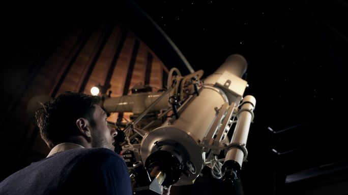 一个人正在使用天文台的天文望远镜